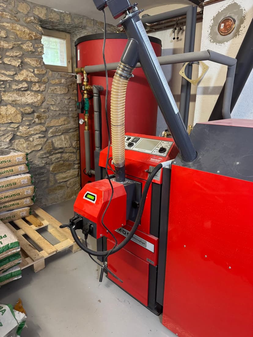 Instalace ATMOS pellet kotle v kotelně se skladem pelet na paletách